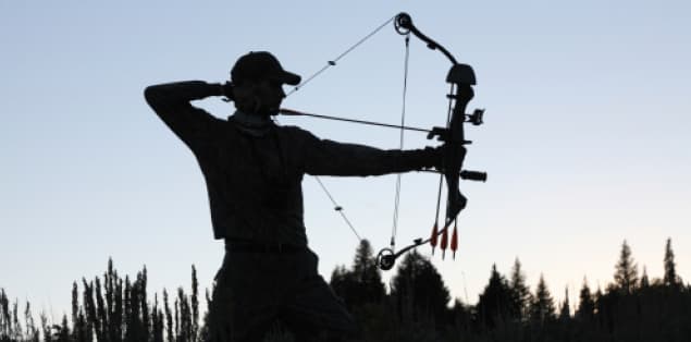 Person drawing the bowstring of a compound bow