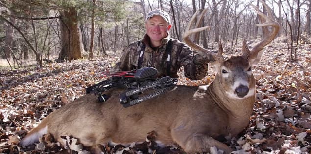 Hunter wearing camouflage near deer